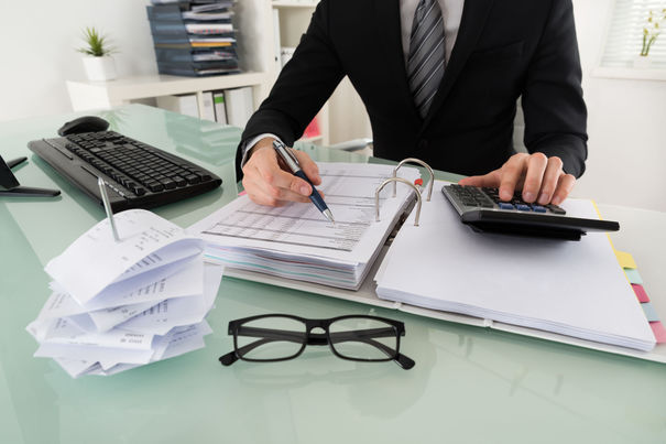 54191004 - close-up of businessman calculating tax in office